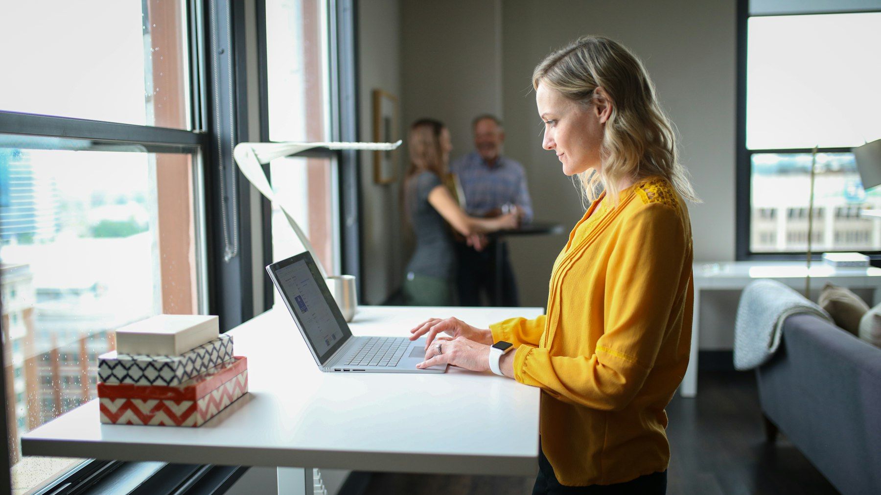 Professional working at a standing desk in a bright office