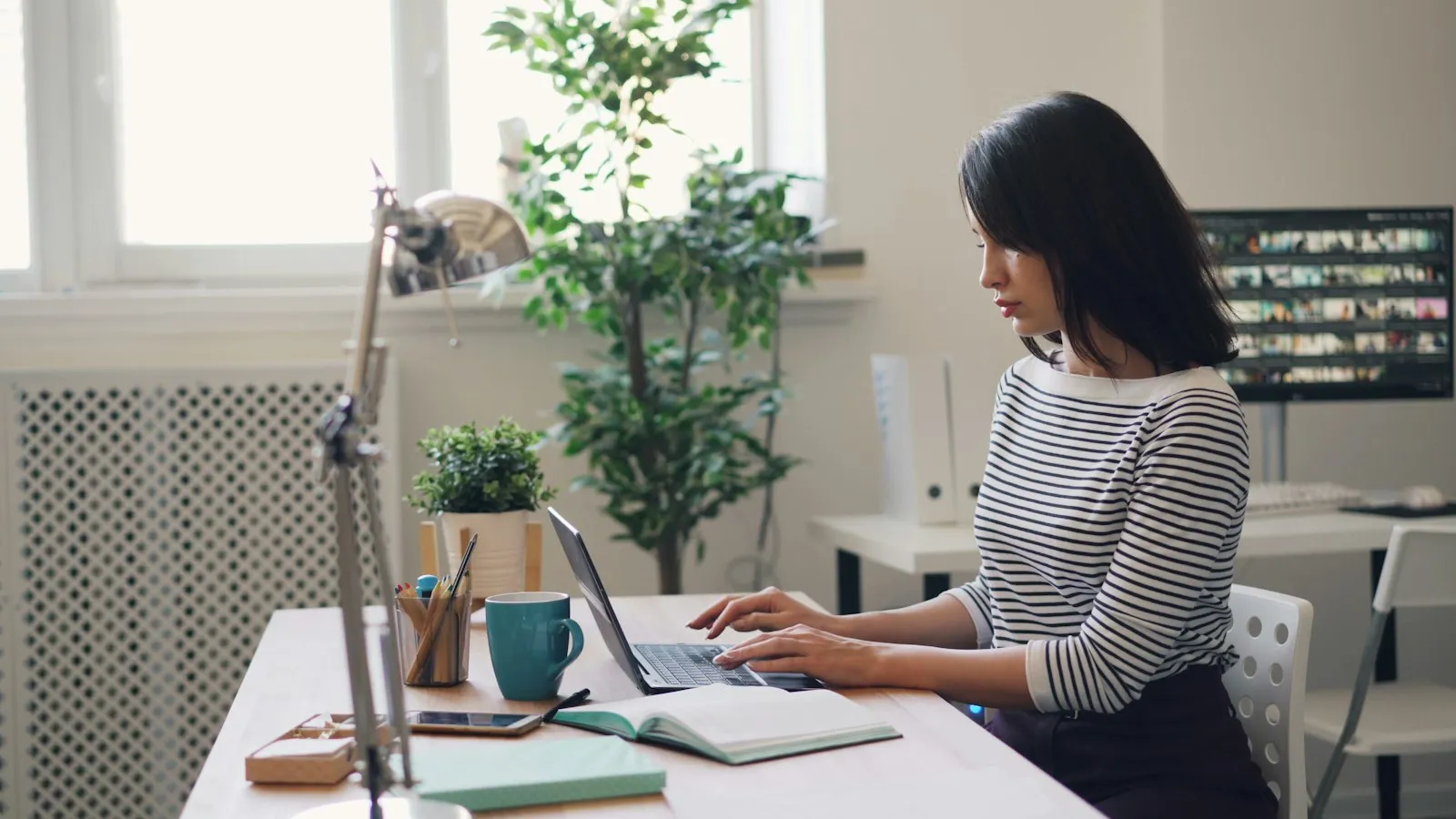 Accounting professional working on a laptop at a bright desk